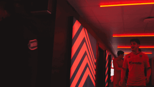 Man in Allianz Jersey Walking Down Hallway