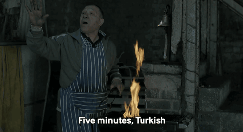 Man in Apron by Fire Saying Five Minutes Turkish