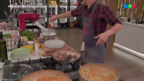 Man in Apron Cooking on Stove