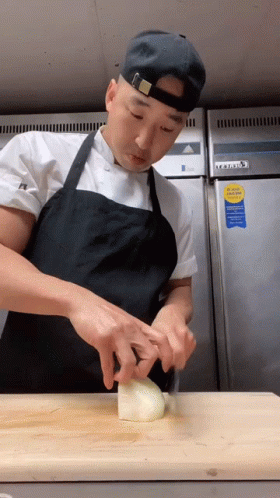 Man in Apron Cutting Onion