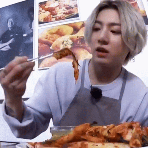 Man in Apron Eating Pizza With Chopsticks