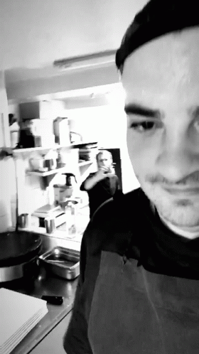 Man in Apron Taking Selfie in Kitchen