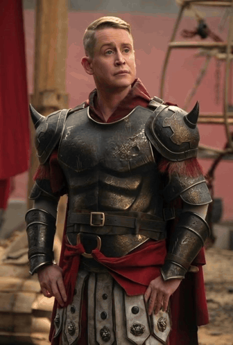 Man in Armor and Red Cape by Red Wall