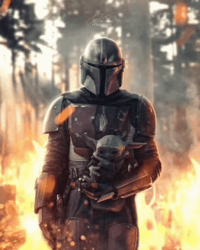 Man in Armor Holding Baby Yoda Before Forest Fire