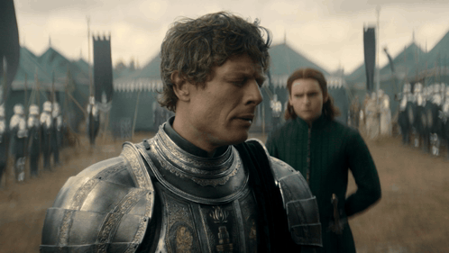 Man In Armor In Field With Woman Behind GIF