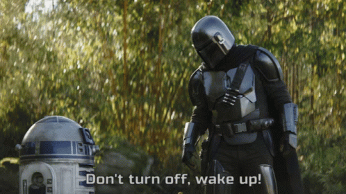 Man in Armor Next to R2D2 Says Wake Up