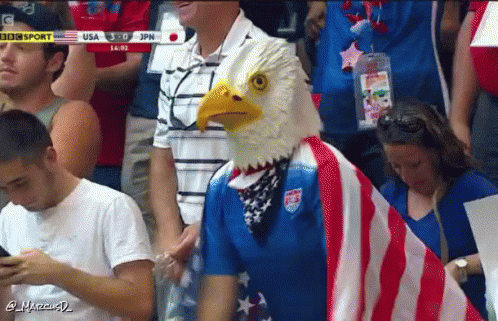 Man In Bald Eagle Mask Stands In Crowd GIF