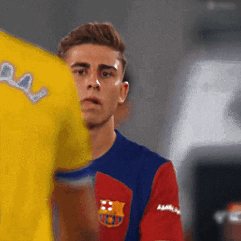 Man In Barcelona Jersey Next To Man In Yellow Shirt GIF