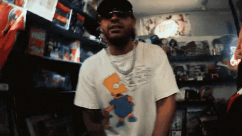 Man in Bart Simpson Shirt With Toy Shelf