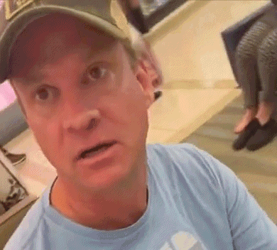 Man in Baseball Cap and Blue Shirt Looking at Camera