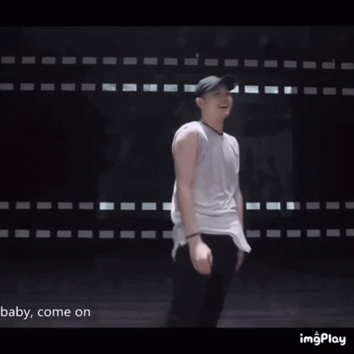 Man in Baseball Cap and Sunglasses in Front of Wall Saying Baby Come On