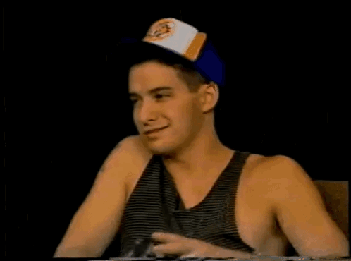 Man in Baseball Cap and Tank Top Pointing Up