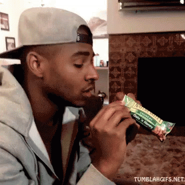 Man in Baseball Cap Eating Oats and Honey Bar