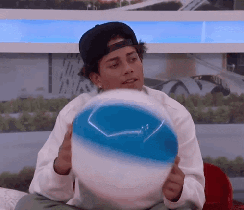 Man in Baseball Cap Holding Beach Ball
