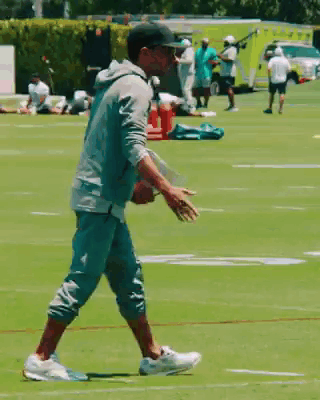 Man in Baseball Cap Walking on Football Field