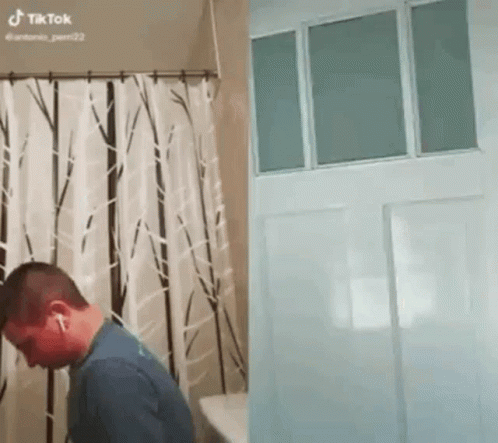 Man in Bathroom Next to Door and Shower Curtain