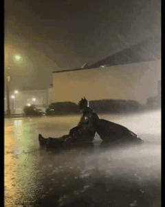 Man in Batman Costume Sitting in Rain