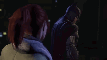 Man in Batman Suit Beside Woman in Dark Room