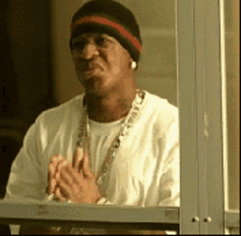 Man in Beanie and Necklace Looking Out Window