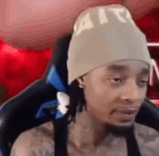 Man In Beanie Sitting And Looking At Camera GIF