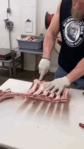 Man in Bearded David Tank Top Cuts Meat