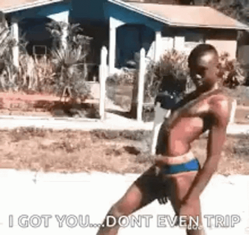 Man in Bikini Walking Down Sidewalk