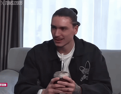 Man In Black Adidas Jacket On Grey Couch GIF