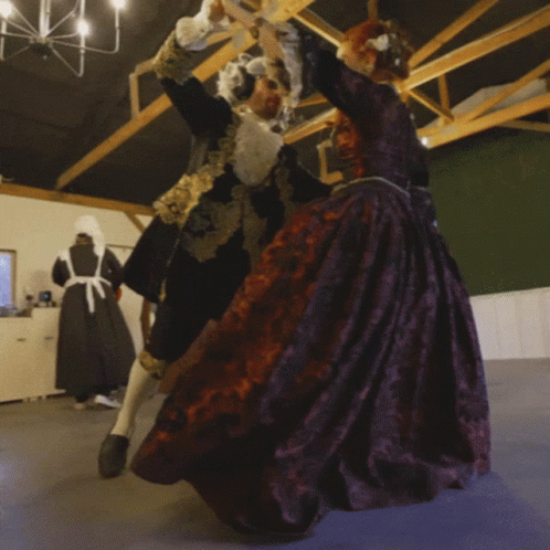 Man in Black and Gold Dancing with Woman in Purple