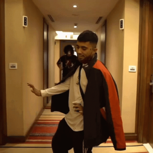 Man in Black and Red Jacket Dancing in Hallway