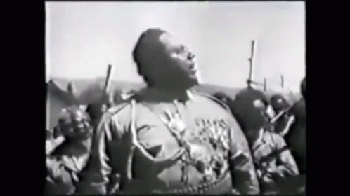 Man In Black And White Facing Armed Crowd GIF