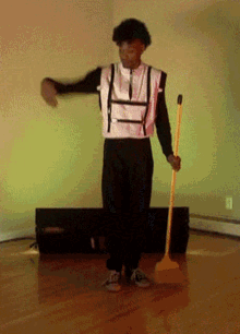 Man in Black and White Outfit Holding Yellow Mop