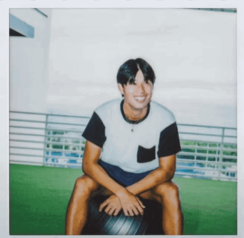 Man in Black and White Shirt Sitting on Black Ball