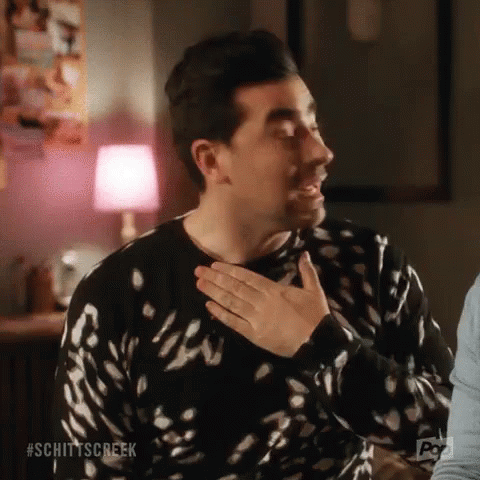 Man in Black and White Sweater Holding Hands to Chest