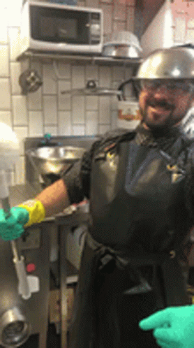 Man in Black Apron and Hard Hat in Kitchen