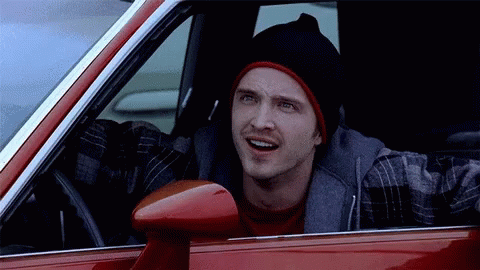 Man In Black Beanie And Plaid Shirt In Red Car GIF