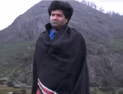 Man In Black Blanket At Mountain GIF