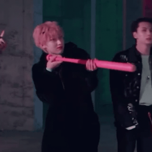 Man In Black Coat Holding Pink Baseball Bat GIF