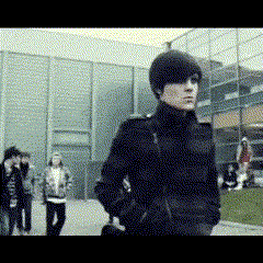 Man In Black Coat In Front Of Building GIF