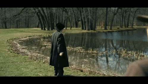Man in Black Coat Near Lake