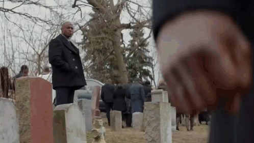 Man In Black Coat Standing In Cemetery With Crowd GIF