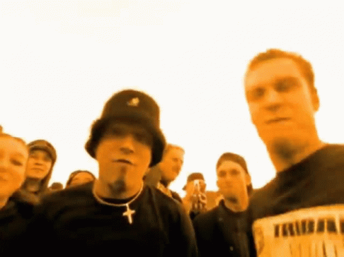 Man in Black Hat and Cross Necklace in Crowd