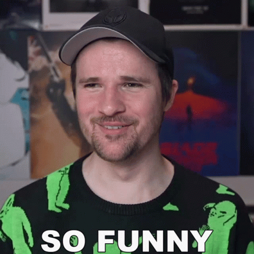 Man in Black Hat and Green Sweater Saying So Funny