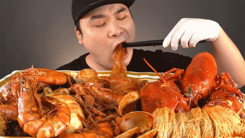 Man in Black Hat Eating Seafood