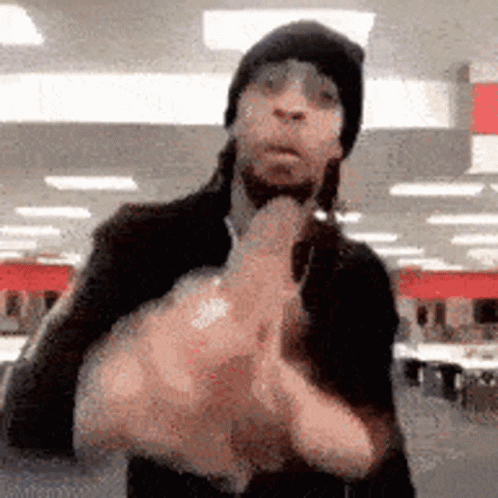 Man in Black Hat Giving Middle Finger in Store