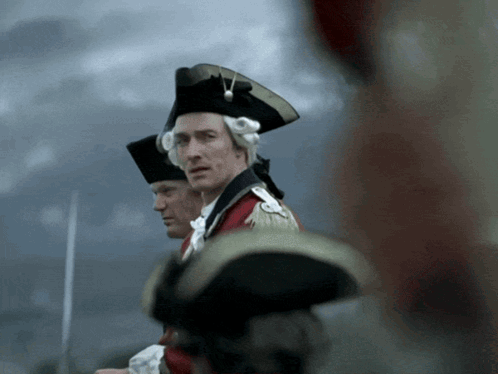 Man In Black Hat Next To Man In Red Coat GIF