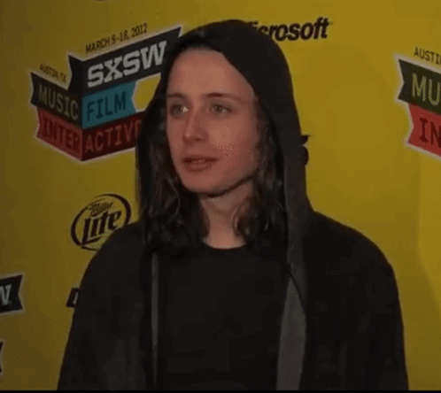 Man in Black Hoodie in Front of SXSW Sign