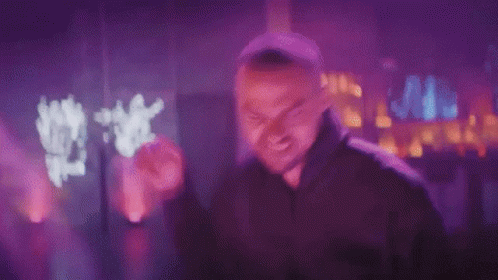 Man In Black Hoodie Making Funny Face In Purple Light GIF