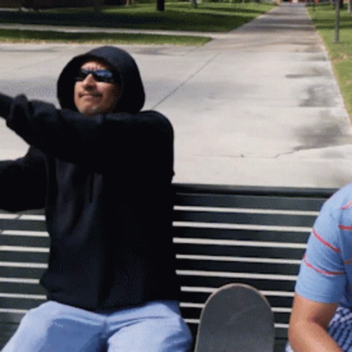 Man in Black Hoodie Sitting on Bench With Skateboard