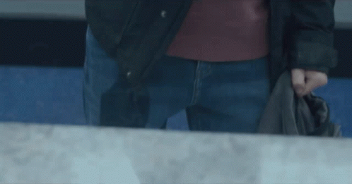 Man in Black Jacket and Blue Jeans Holding Jacket