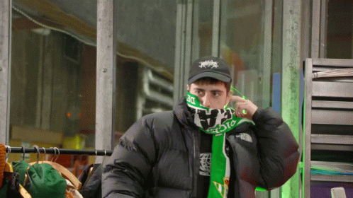 Man in Black Jacket and Green Scarf Saying The North Face